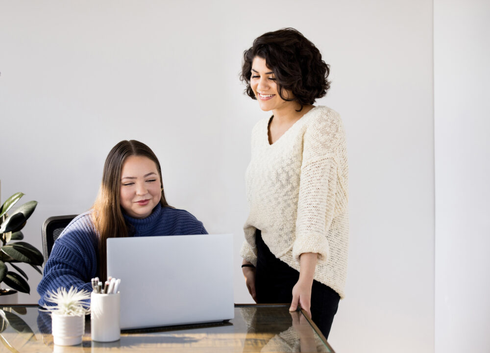 two women looking at a laptop screen